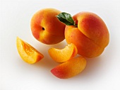 Two whole apricots and apricot slices