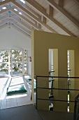 Open-plan attic room with white-painted wooden ceiling and balcony door