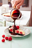 Raspberry tart with white chocolate and a biscuit base, served with chocolate sauce