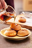 Drizzle aebleskiver (stuffed pancakes) with maple syrup