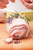 Tying rolled sucking pig with kitchen twine