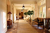 Antique furniture in spacious foyer with old terracotta floor in Mediterranean villa