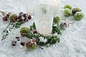 Frosted tea light holders and apples in the snow