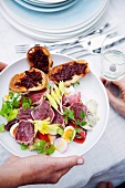 Riviera salad with raw tuna fish fillets and crostini with tapenade