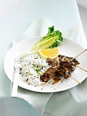 Pork kebabs with rice and spring onions