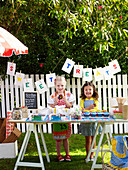 Two girls selling sweets at a school fete