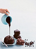 Pouring chocolate icing onto a chocolate pudding