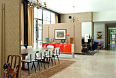 Tisch und Stühle im Fiftiesstil in offenem Ess- und Wohnbereich durch Raumteiler getrennt in klassisch modernem Haus