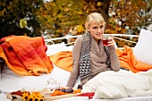 Young woman drinking tea on couch in garden