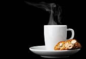 Biscotti (Italian almond biscuits) and a cup of espresso against a black background