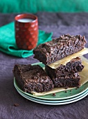 Dark Chocolate Gluten Free Brownies Stacked on Stacked Plates; Glass of Milk