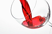 Rotwein fliesst ins Weinglas