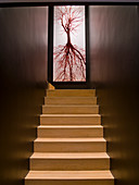 Treppenhaus mit hellen Holztreppen, dunklen Wänden und einem Poster-Foto