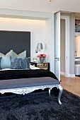 Bettbank im Rokokostil und modernes Doppelbett auf Langflor-Teppich