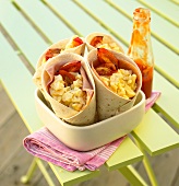 Wraps filled with scrambled egg, ham and tomatoes for breakfast