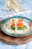 Remoulade being poured over salmon fillet