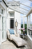 Art Deco-style chaise longue with white upholstery in conservatory