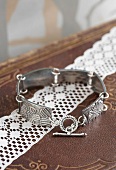 Hand made, silver link bracelet with floral pattern on lace