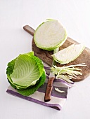 White cabbage, partially sliced, on a chopping board