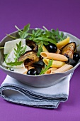 Pasta salad with aubergines, olives, rocket and parmeasn