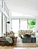 Sofa set with pale upholstery and metal table in modern living room in contemporary glass and steel extension