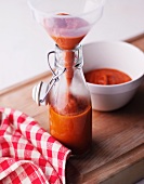 Homemade ketchup being poured into a bottle
