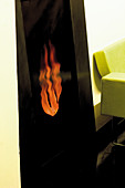 Picture of flames and corner of lime green designer sofa in living room