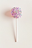 A cake pop decorated with sugar sprinkles