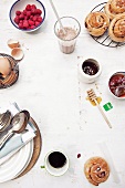 Frühstückstisch mit Gebäck, Ahornsirup, Kaffee, Eiern und Himbeeren
