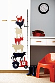 Gemalte Tiermotive neben Messlatte an Kinderzimmerwand