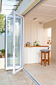 Terrace with open folding door and view of bar stools and a white counter