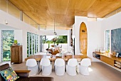 weiße Retro Schalenstühle am Esstisch in offenem Wohnraum mit zeitgenössischer Architektur