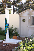 Garden with DIY outside shower in front of a small garden house