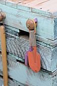Gardening tools hanging from potting table made from wooden pallets