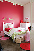 Child's bedroom with white, traditional bed against red wall with stucco frieze