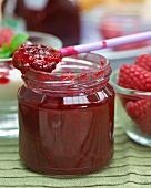 Raspberry jam in a jar and on a spoon