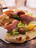Tarte flambée topped with goose breast, chestnuts, white cabbage and sliced pears