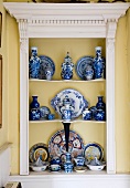 Sammlung wertvollen, chinesischen Porzellans in Einbauregal mit Holzumrahmung im klassizistischen Stil