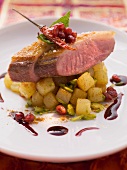 Fried duck breast with pomegranate seeds, fired potatoes and pistachios