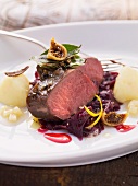 Fried saddle of venison on a bed of red cabbage with figs