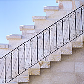 Treppenaufgang mit schmiedeeisernem Geländer entlang der Hausmauer