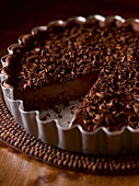 Chocolate tart with chocolate curls, sliced