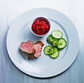 Medium-rare pork fillet with cucumber and cranberries