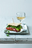 A pastrami, lettuce and herb sandwich with tomato relish