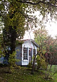 Autumnal atmosphere in garden with small wooden hut