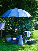Vintage Waschutensilien unter aufgespanntem Sonnenschirm im Garten