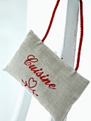 A linen bag embroidered with a words