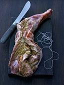 Spicy stuffed leg of lamb being tied together