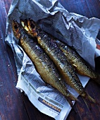 Three smoked mackerels on newspaper