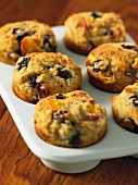 Blueberry and peach muffins in a muffin tin